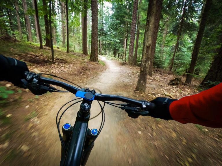 Mountain,Biker,Riding,On,Flow,Single,Track,Trail,In,Green