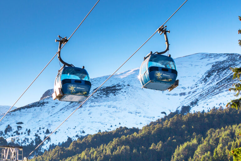 Two Bansko cable car cabins and snow mountains peaks, Bulgaria